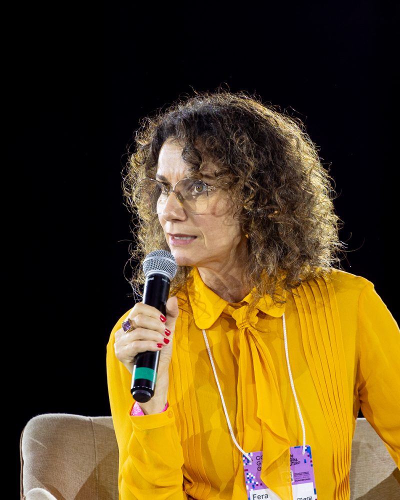 Fera Carvalho Leite com o microfone na mão no painel