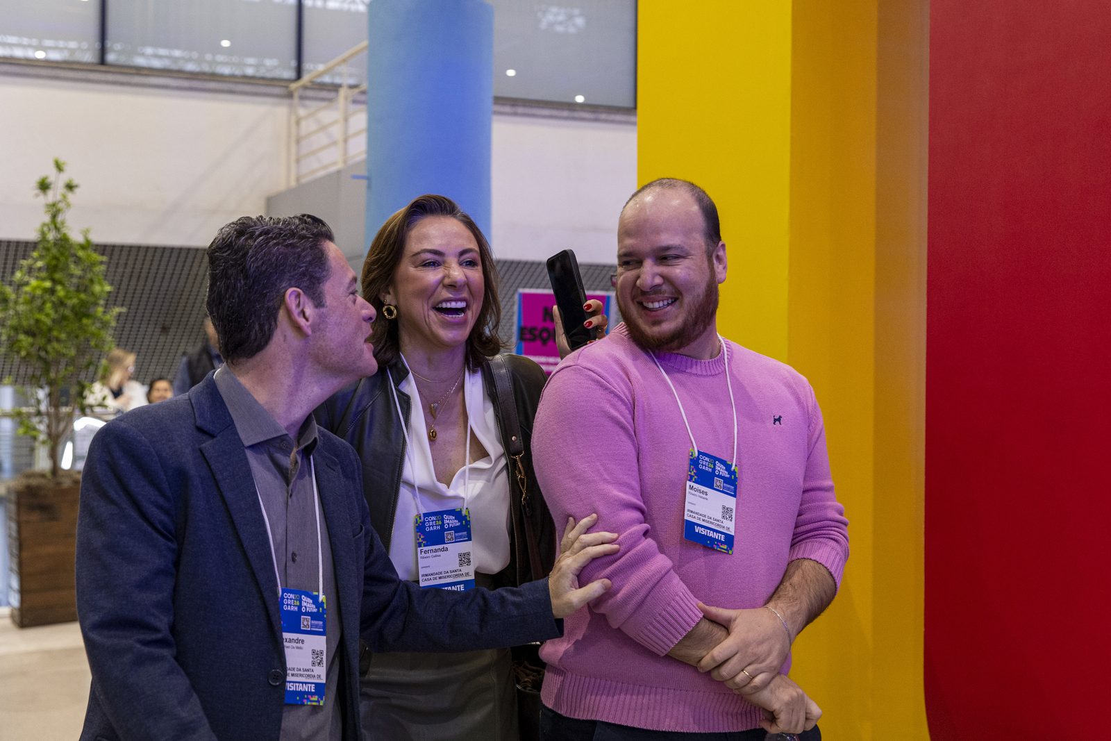 Três participantes posam para foto no evento
