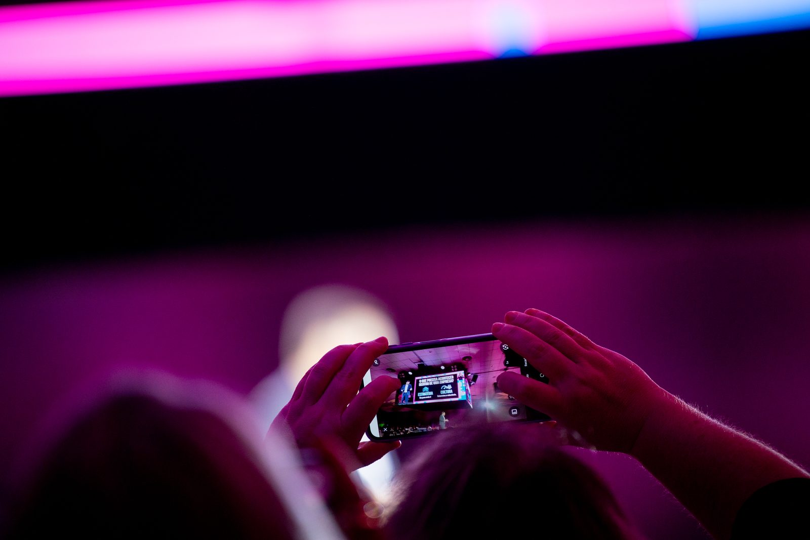 Participante fotografa o palco principal com o celular