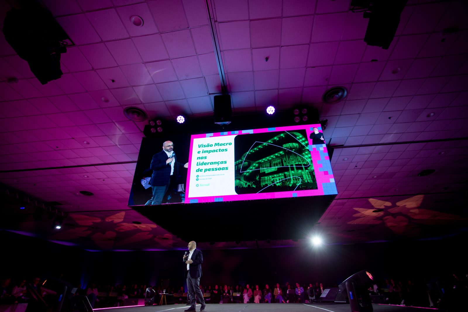 André Nunes de Nunes no palco principal, sob o telão com o título da palestra