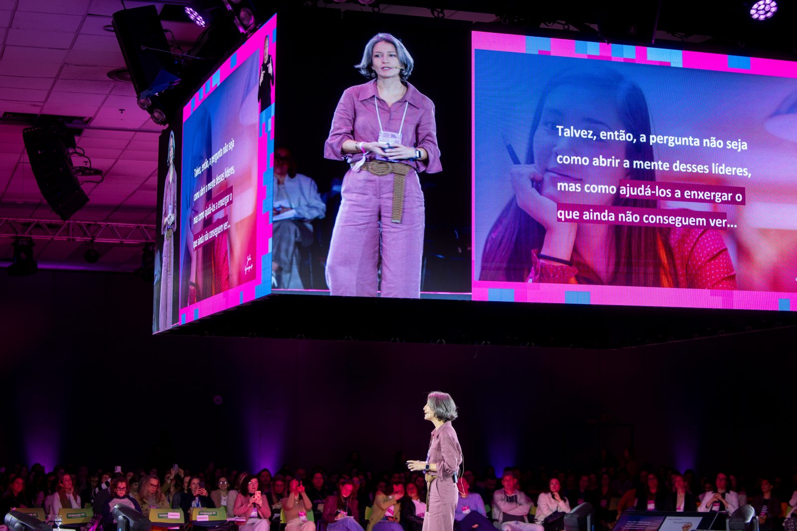 Julia Gianzanti no palco principal, com a imagem dela e um slide no telão