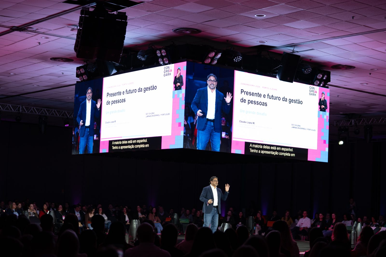 Claudio Lopez M. no palco principal, sob o telão com o título da palestra