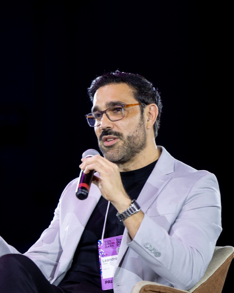 Leandro Firme fala ao microfone no painel