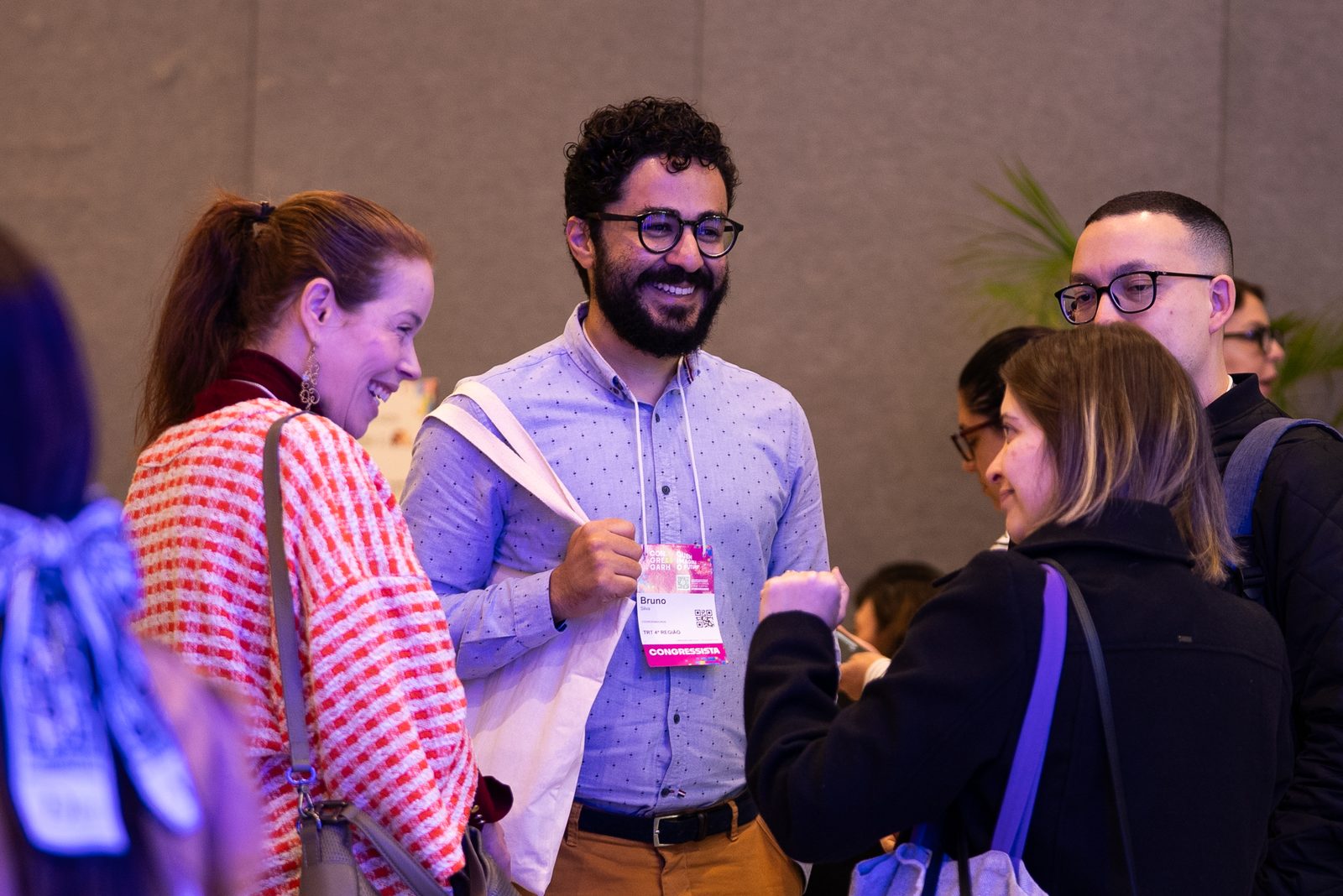 Participantes conversam e sorriem na feira