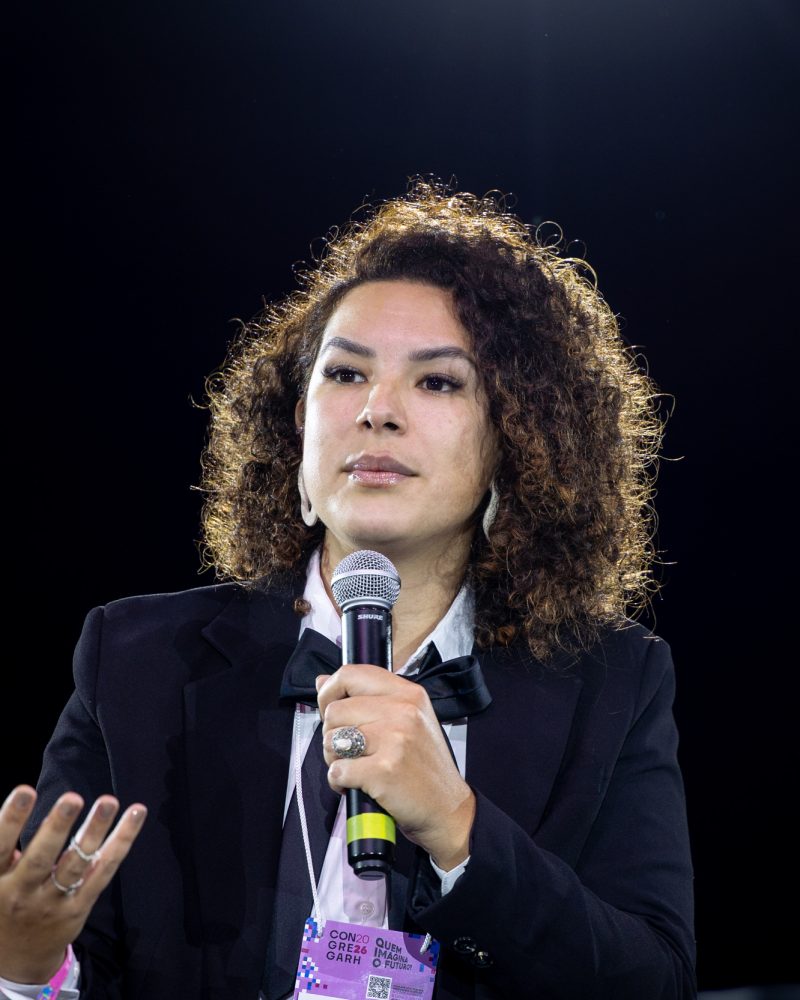 Daniele Lopes fala ao microfone no painel