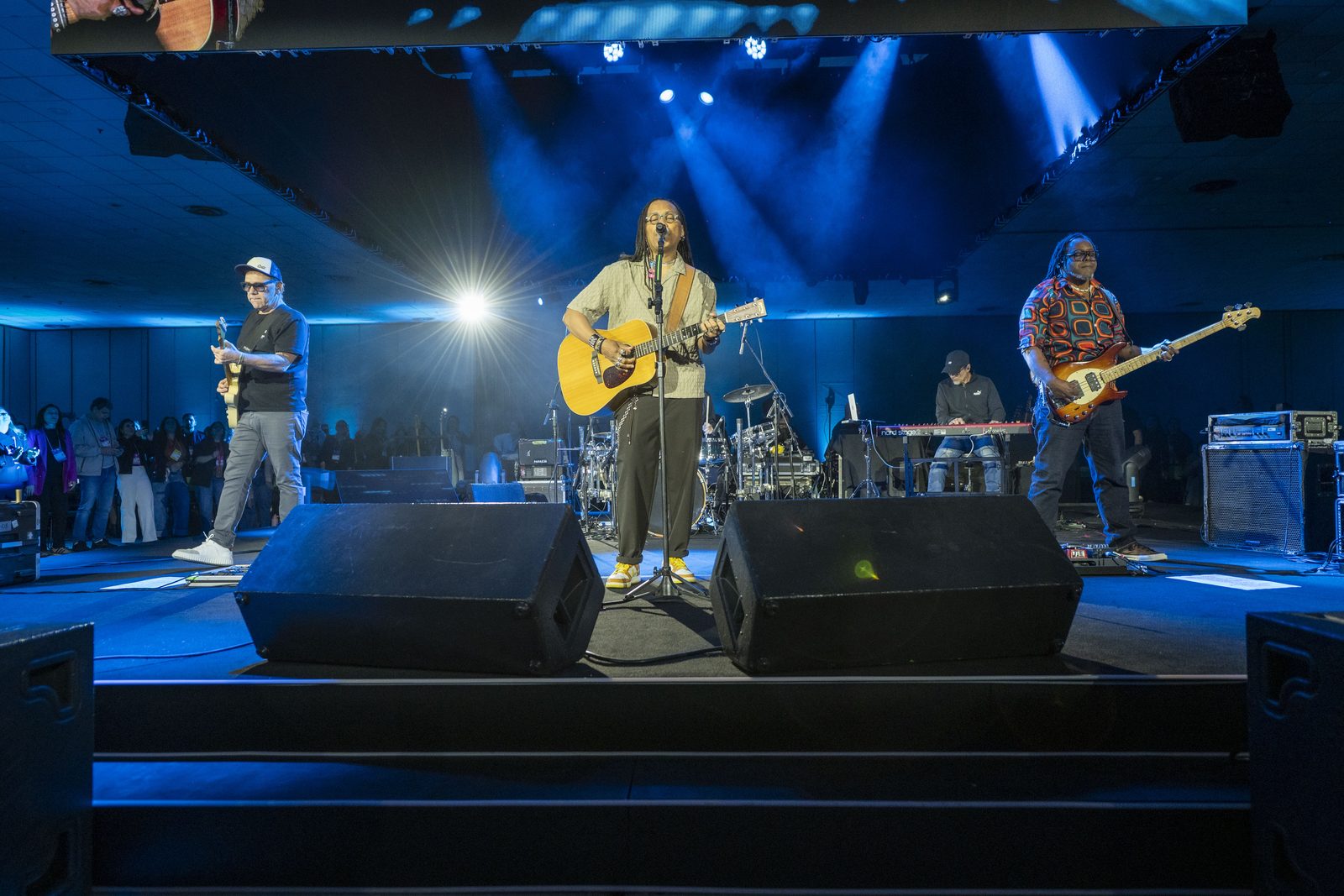 A banda Papas da Língua toca no palco principal, sob luz azul