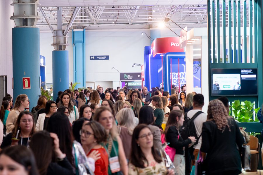 Corredor da ExpoCongregarh cheio de participantes entre os estandes