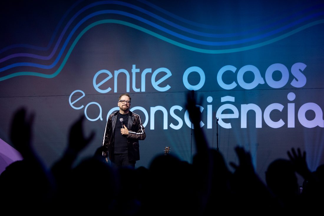 Público de mãos erguidas diante do palco principal