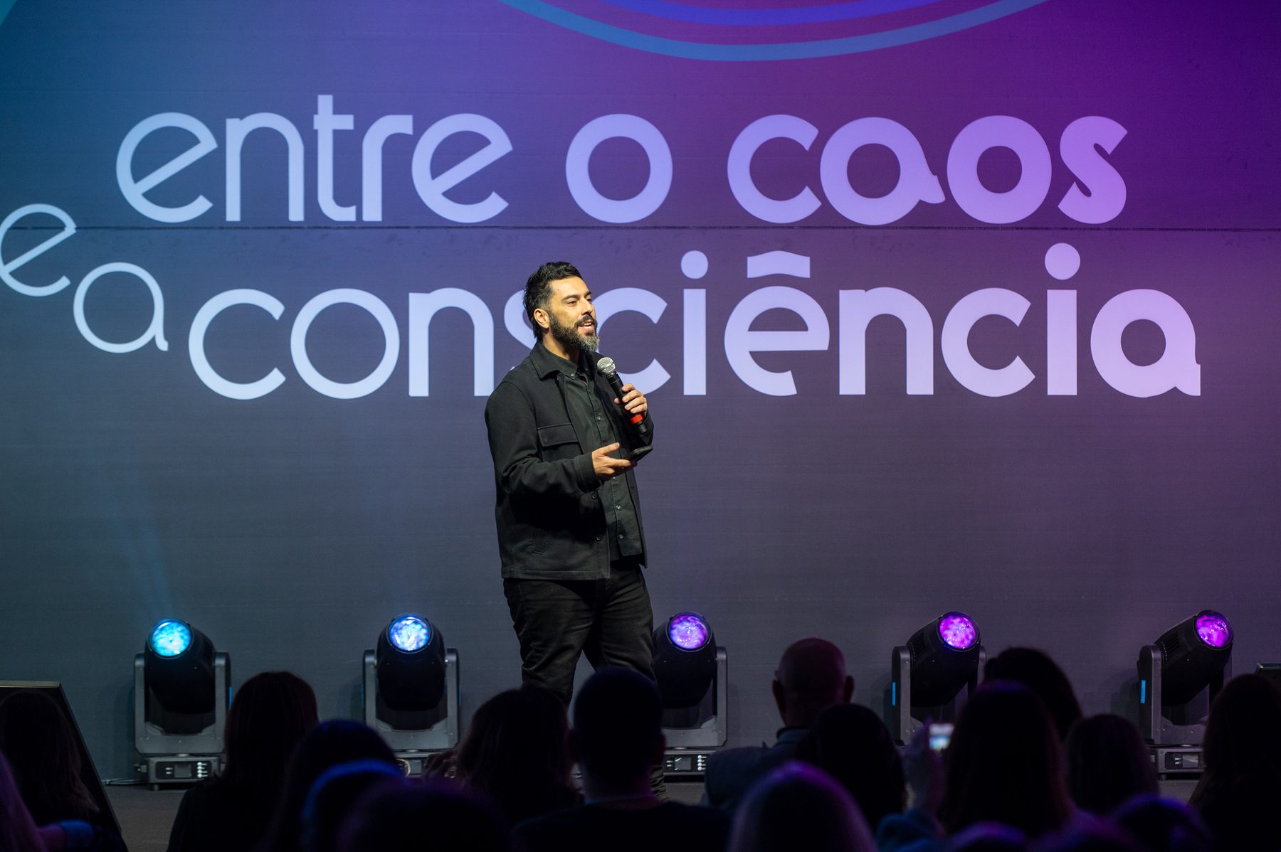 Palestrante no palco principal do CONGREGARH 2025, sob a tipografia gigante do tema da edição